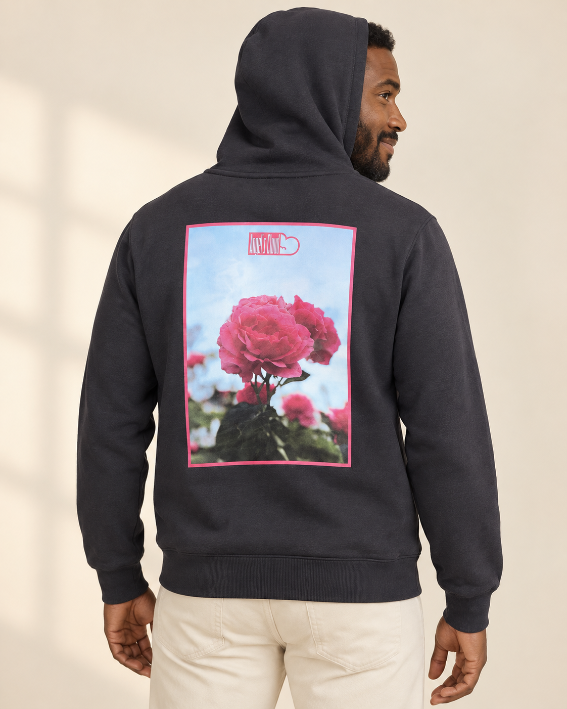 Father wearing a black Afternoon Blossom Hoodie, showing the pink-framed rose artwork on the back.