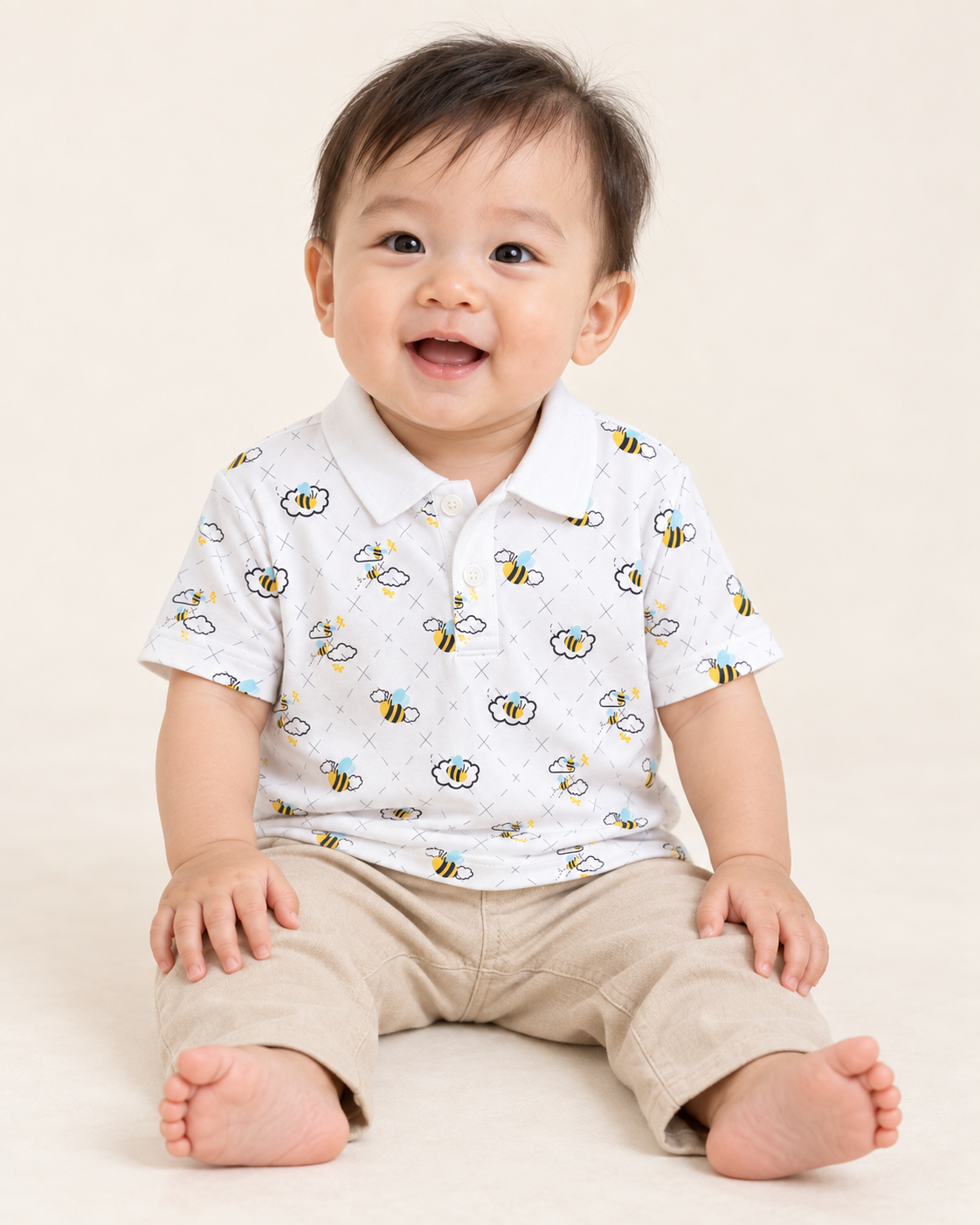 Baby wearing a white Buzzed Polo with a bee-and-cloud print.