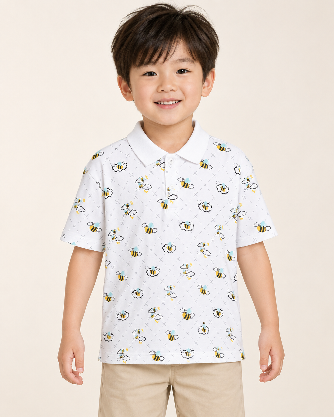 Child wearing a white Buzzed Polo with a bee-and-cloud print.