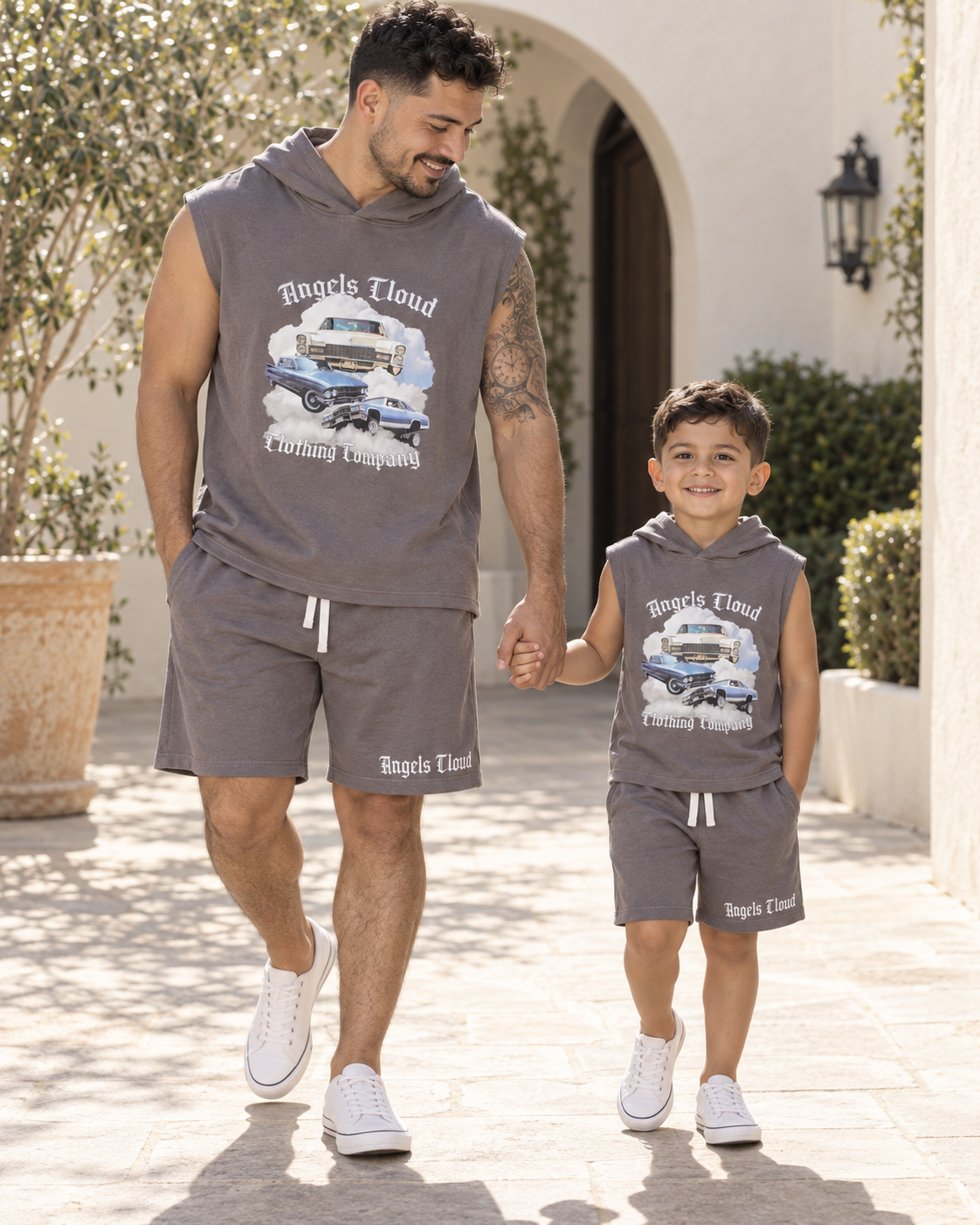 Father and child wearing matching gray Caddy Dreams sleeveless hooded tops and shorts.
