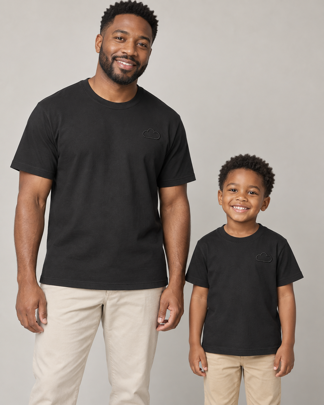 Father and child wearing matching Midnight Classic Black Tees with subtle cloud outlines.