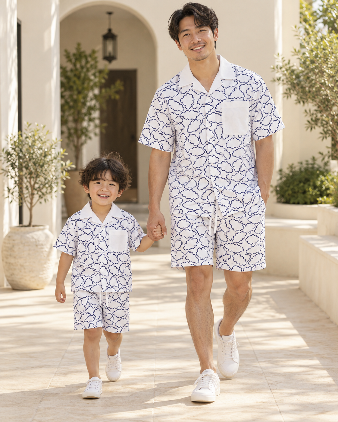 Father and child wearing matching white Relaxed Clouds printed shirts and shorts.